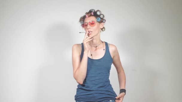 Ama de casa con gafas y rulos fuma una jamba con marihuana en el inodoro — Vídeo de stock