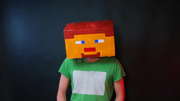 Ήρωας του ηλεκτρονικού παιχνιδιού στη ζωγραφισμένη μάσκα γρατσουνιές το κεφάλι του με το χέρι του. — Αρχείο Βίντεο
