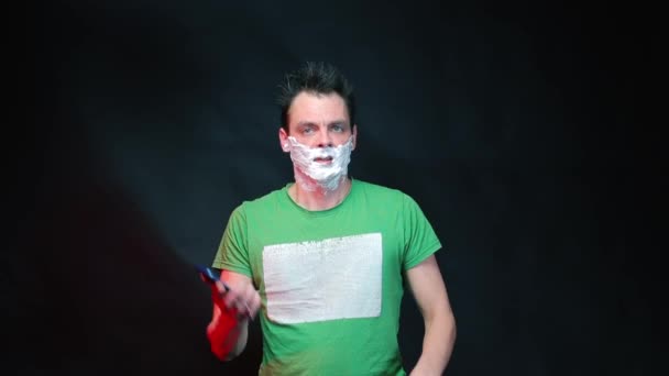 Чоловік в зеленому одязі з піною для гоління на обличчі . — стокове відео