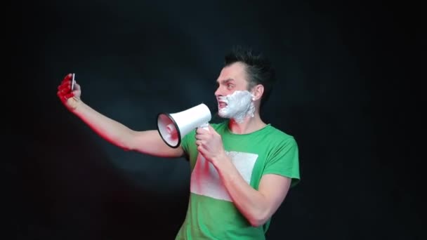 Homem agressivo com espuma no rosto, gritando em um megafone . — Vídeo de Stock