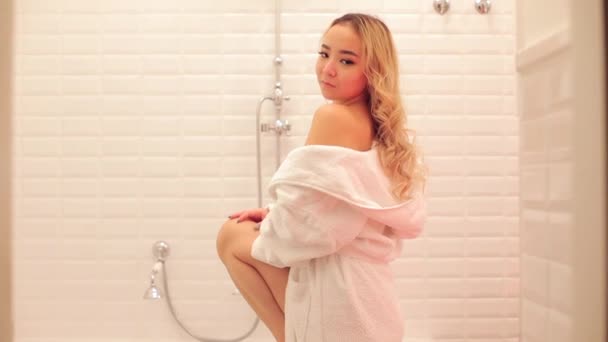 A girl of Asian appearance posing in the bathroom. — Stockvideo