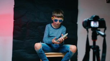 Gözlüklü genç bir gangster video mesajı çekiyor..