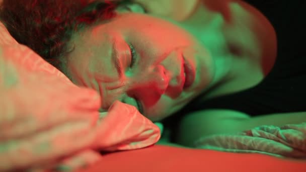 Крупним планом дівчина плаче на подушці в ліжку вночі . — стокове відео