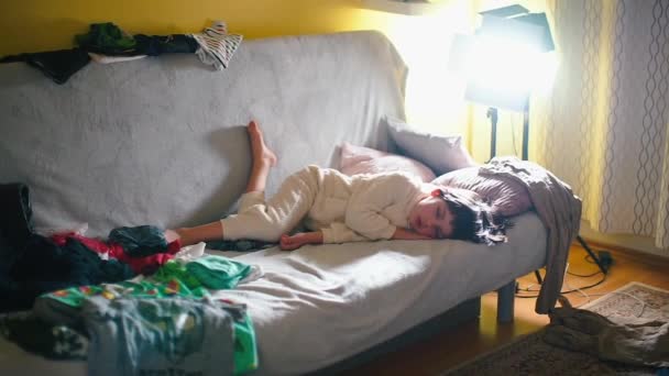 소파에서 하얀 잠옷을 입고 자고 있는 아기. — 비디오