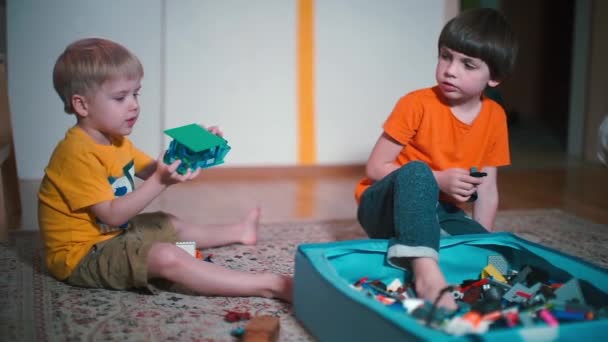 Two boys play constructor on the floor in kindergarten — Stock Video
