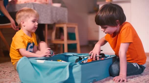 Twee kinderen spelen bouwvakker op de vloer. — Stockvideo