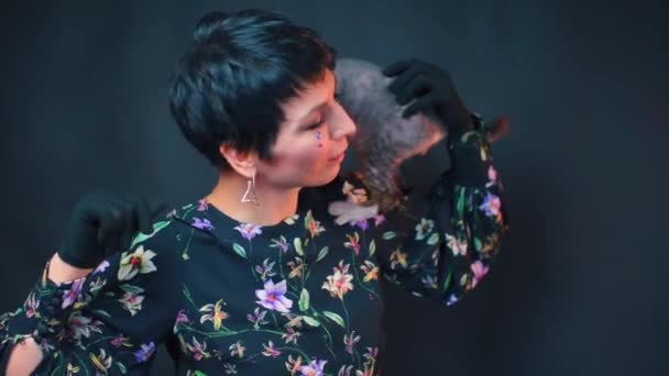 Egy fiatal lány táncol egy macskával a vállán. — Stock videók
