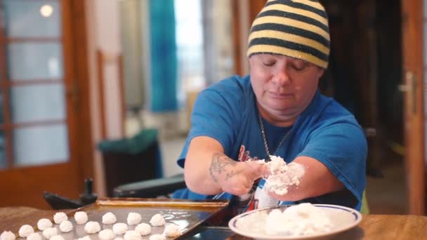 Homme handicapé fait des gâteaux ronds dans une usine de confiserie . — Video