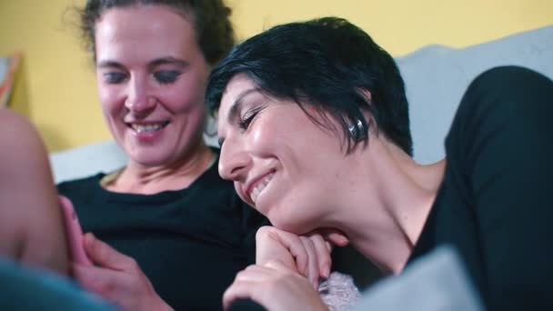 Due ragazze gioiose visualizzare le foto su uno schermo dello smartphone . — Video Stock