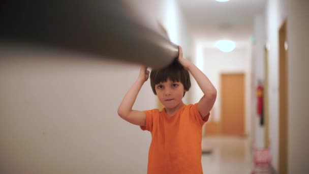 Chlapec drží dlouhou dýmku v rukou a nohou rukavici. — Stock video