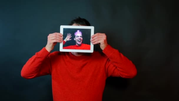 A man holds a tablet instead of a face. — Stock Video