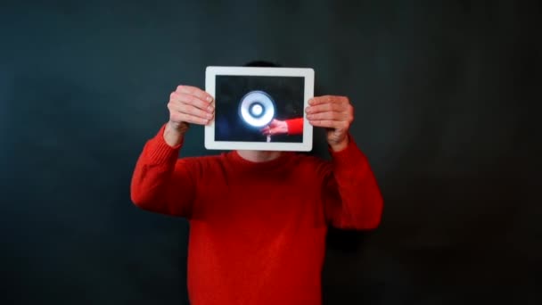 Un hombre vestido de rojo sostiene una tableta en sus manos . — Vídeo de stock