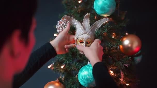 Közelkép egy irodai munkásról, aki karácsonyfát díszít fekete alapon. — Stock videók