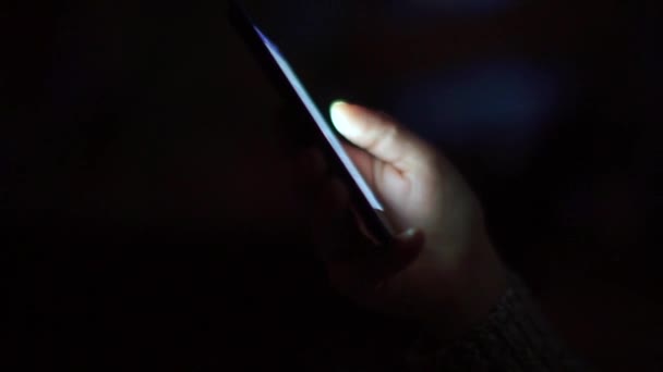 Close-up de usar um smartphone em uma sala noturna — Vídeo de Stock