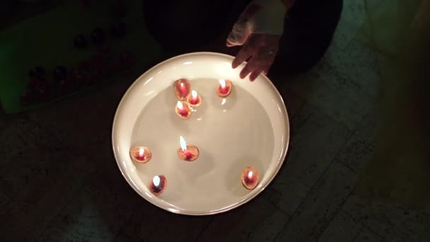 Mama stellt einen Kerzenständer mit einer Kerze auf das Wasser. — Stockvideo