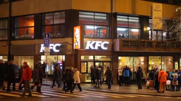 Вечором люди гуляють по перехресті біля ресторану.. — стокове відео