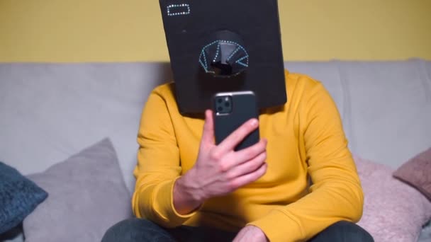 A man in a camera mask on his head uses a new smartphone at a masquerade party. — Stock Video