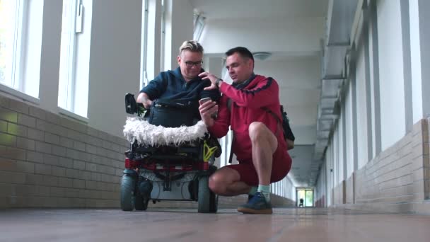 Yardımcı engelli kişiye fabrikada güvenli bir şekilde nasıl çalışacağını söyler.. — Stok video
