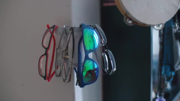 Närbild av glasögon som hänger nära spegeln av ett hus. — Stockvideo