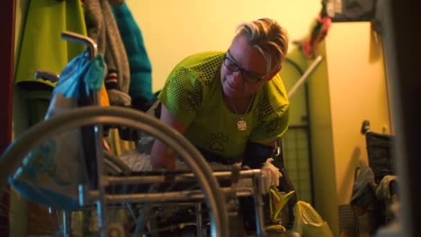 Une femme handicapée est transférée dans un fauteuil roulant dans le couloir de son appartement . — Video