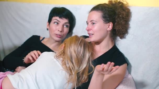 Concept LGBT. Deux mères avec une fille sont allongées sur un canapé — Video