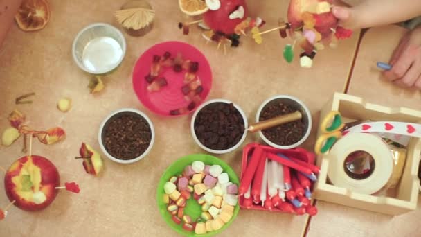 Close-up of the hands of children making fruit toys at a table at school. — Stock Video