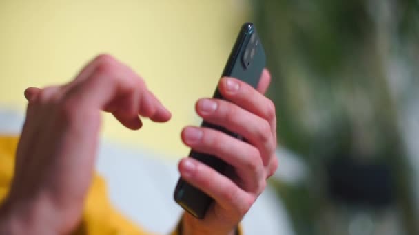 Ένας άντρας χρησιμοποιεί ένα smartphone με τρεις κάμερες στα χέρια του. — Αρχείο Βίντεο