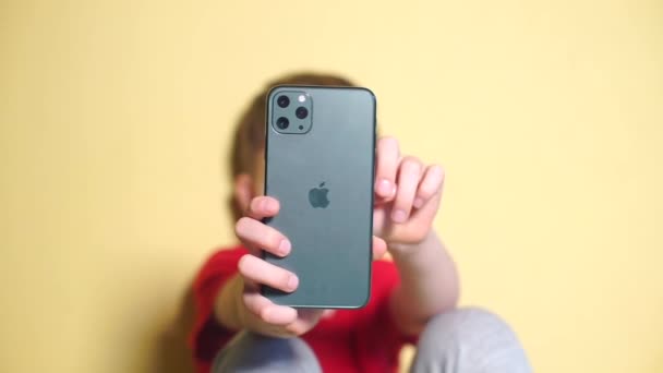 Gros plan d'un smartphone avec trois caméras dans les mains d'un adolescent à la fête — Video