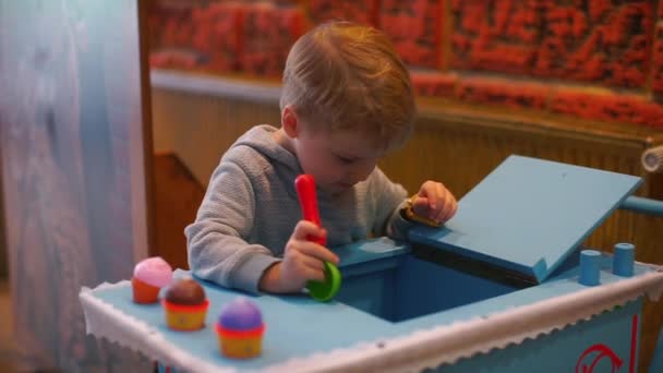 Ein Kind verkauft Spielzeug-Eis und Kuchen. — Stockvideo