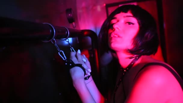 Egy lány egy pipához bilincselve egy nightclub partin. — Stock videók