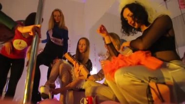 Bir grup kız ayakkabıları ölçer, farklı seçeneklere bakarlar.