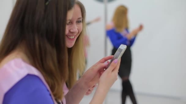 Chicas en una fiesta ver fotos en un teléfono inteligente — Vídeos de Stock