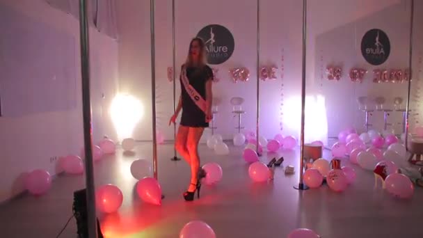 Una ragazza con un vestito nero corto sta ballando vicino al pilone — Video Stock