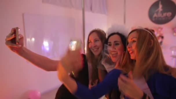 Három nő fényképez egy klubparti bejáratánál. — Stock videók