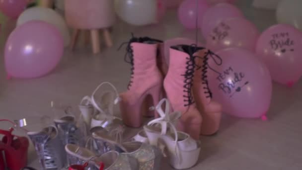 Una gran cantidad de zapatos de mujer están entre los globos — Vídeo de stock