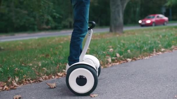 Närbild av en pojke med en tablett i händerna, som står på en Gyroscooter — Stockvideo