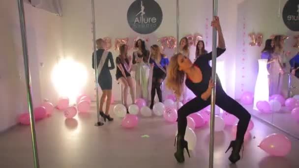 Das Mädchen tanzt auf dem Pylon. Im Hintergrund sind Freundinnen. — Stockvideo