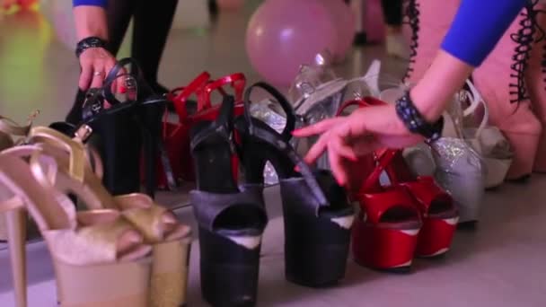 Sok pár női cipő van itt. A lány elvesz egy párat magának.. — Stock videók