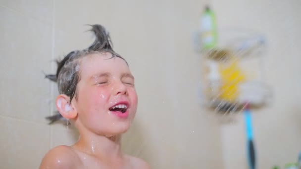 Jongen spelen met een jet van water in de badkamer — Stockvideo