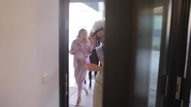 Grupa wesołych dziewcząt wchodzi do małego pokoju, są witani szampanem — Wideo stockowe