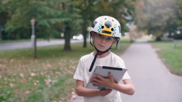 Κοντινό πλάνο ενός αγοριού που χρησιμοποιεί ένα tablet και στέκεται σε ένα Gyroscooter — Αρχείο Βίντεο