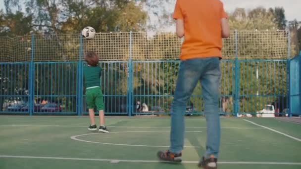 Zwei Brüder spielen Ball auf dem Spielplatz — Stockvideo
