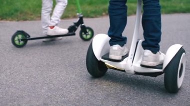 Çocuk segway üzerinde duruyor ve scooter 'ın arka planına karşı bir daire çiziyor.