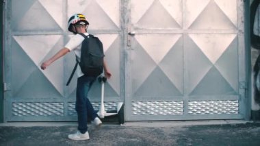 Çocuk segway 'e doğru yürür ve arabayla uzaklaşır.