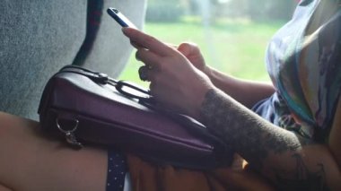Toplu taşıma otobüsüne binen bir kızın elinde akıllı telefon.