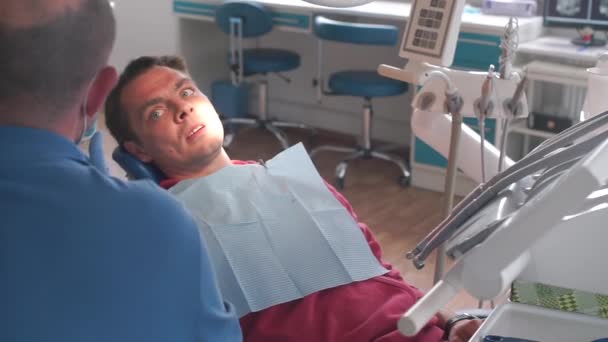 Dentista médico diz diagnóstico de dentes para o paciente — Vídeo de Stock