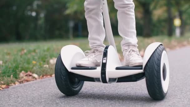 Niño cansado se para en un giroscooter en el camino — Vídeos de Stock