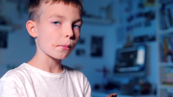 Il ragazzo mangia il cioccolato, poi mostra la lingua di cioccolato — Video Stock