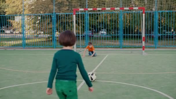 İki okul çocuğu okul bahçesinde futbol topuyla oynuyorlar. — Stok video