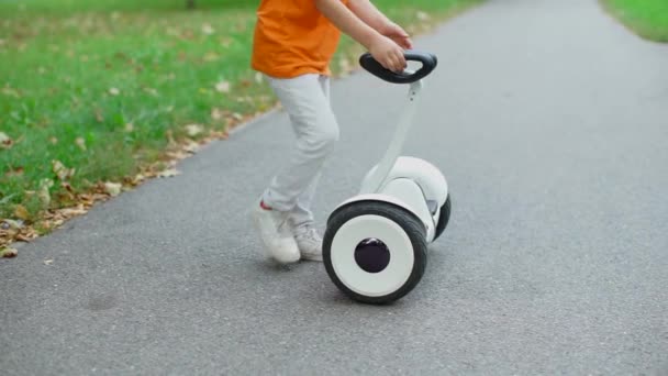 El niño se convierte y sube de la plataforma del GyroScooter — Vídeo de stock